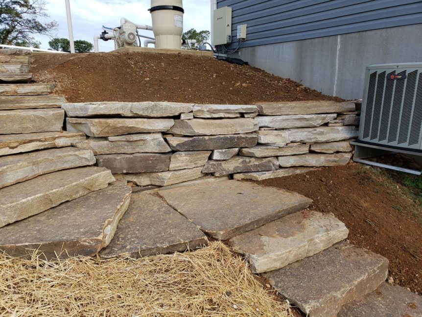 drystack natural stone retaining wall with natural stone stepping stones