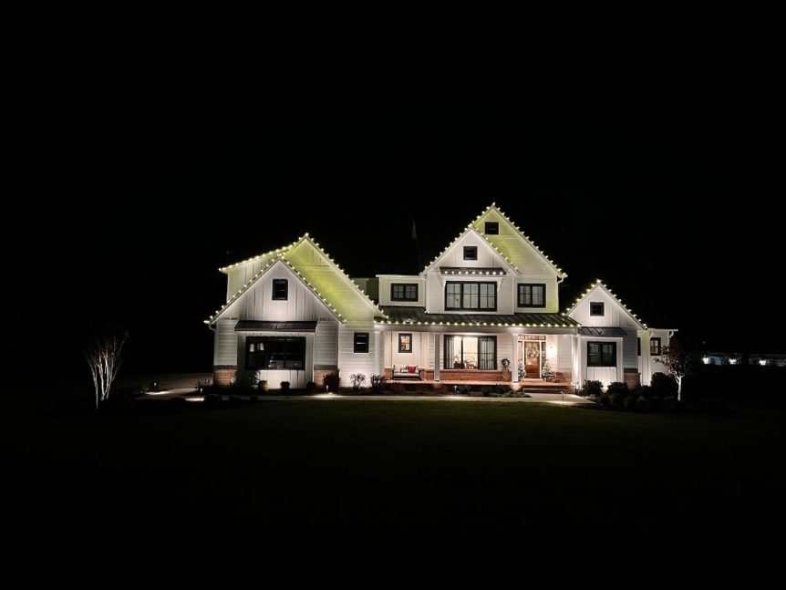 House at night with landscape lighting illuminating it.
